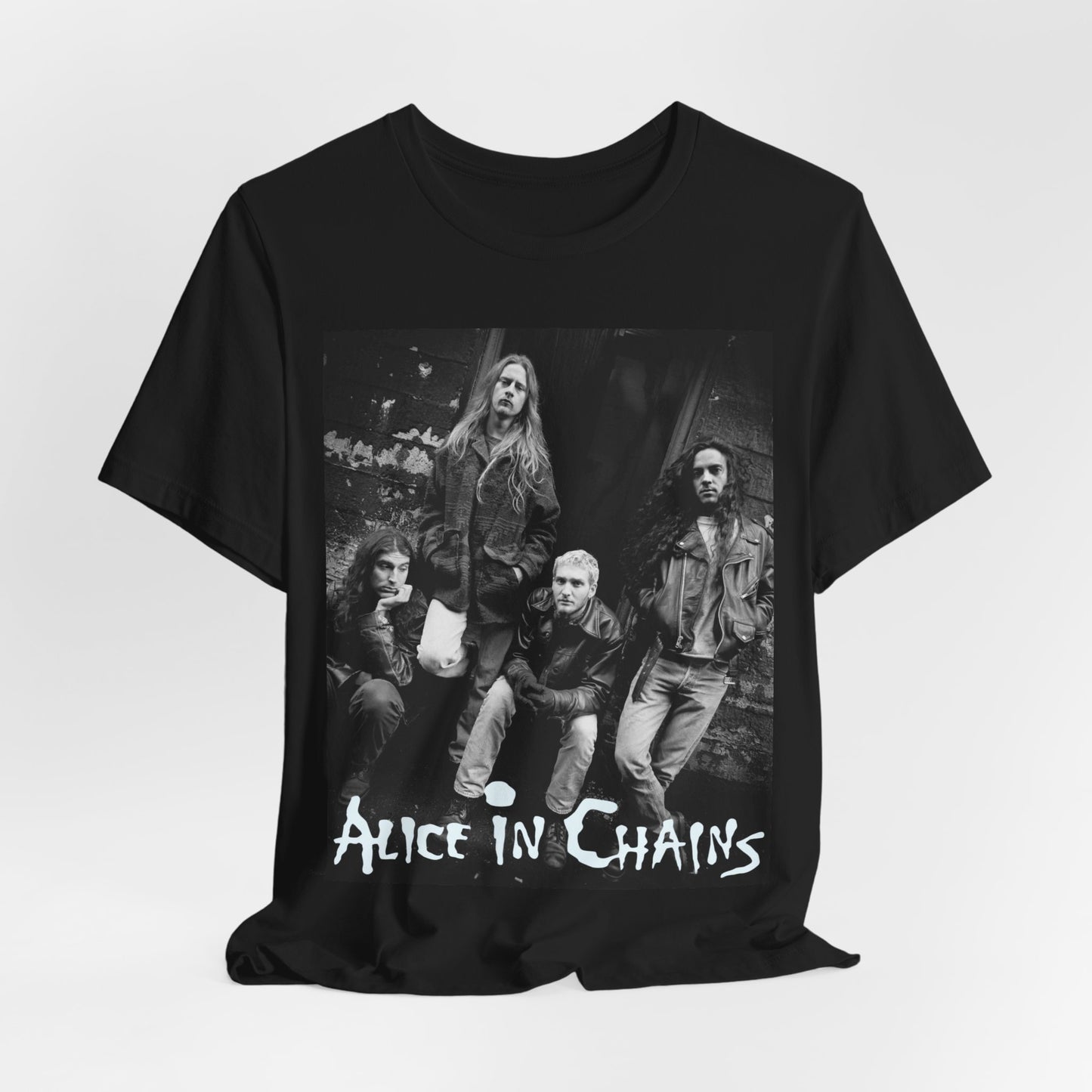 A black graphic t-shirt featuring a 90s black and white photographic portrait of the band Alice In Chains, capturing their iconic grunge look.