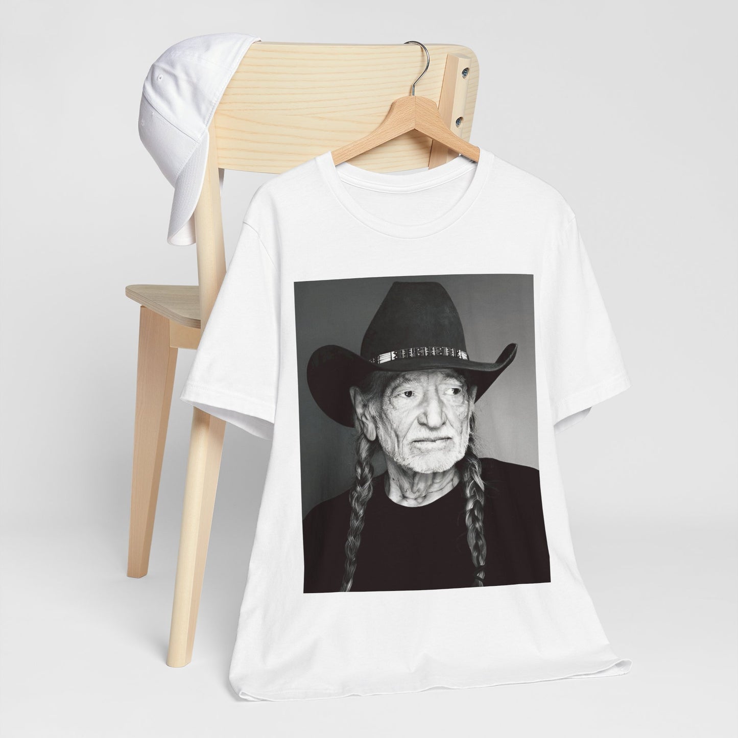A black graphic t-shirt featuring a graphic of Willie Nelson with his iconic guitar 'Trigger'.