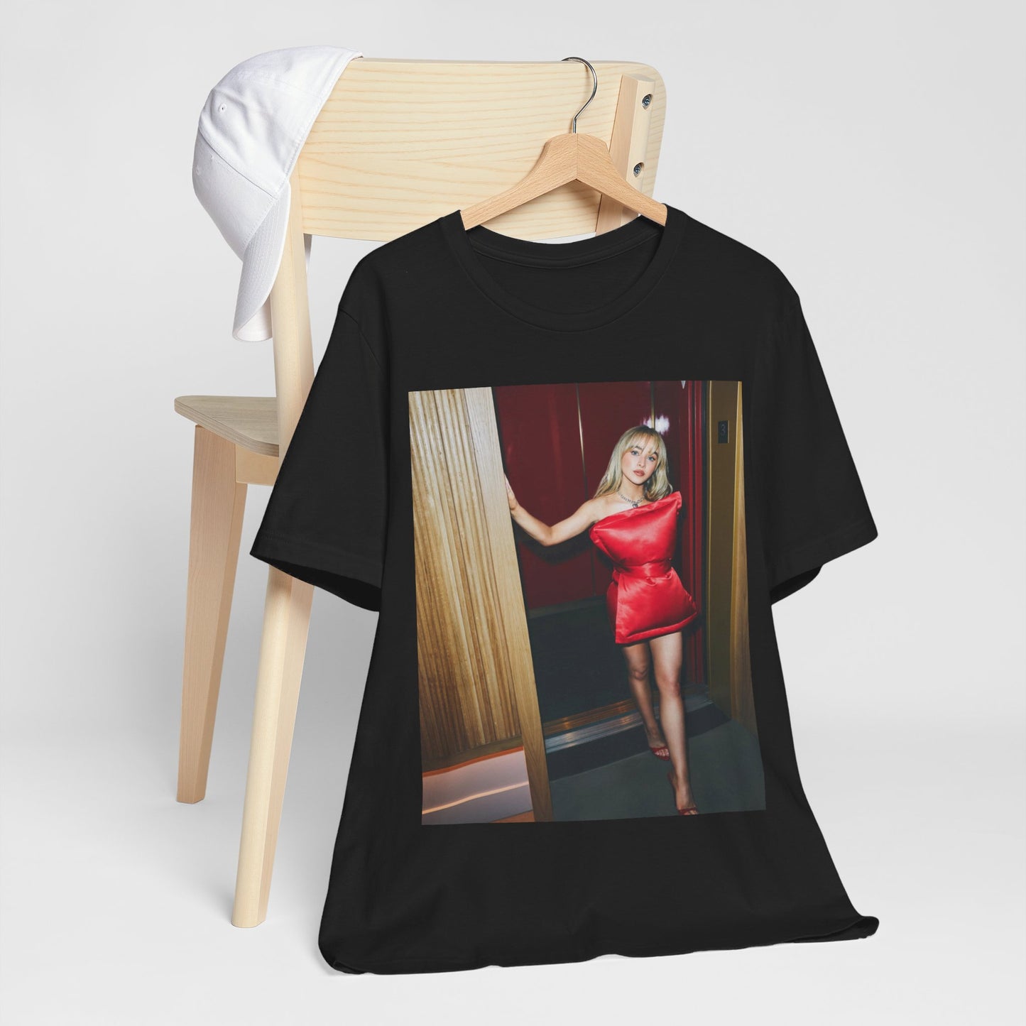 A black graphic t-shirt featuring a graphic of Sabrina Carpenter with 'hot pop vibes'.