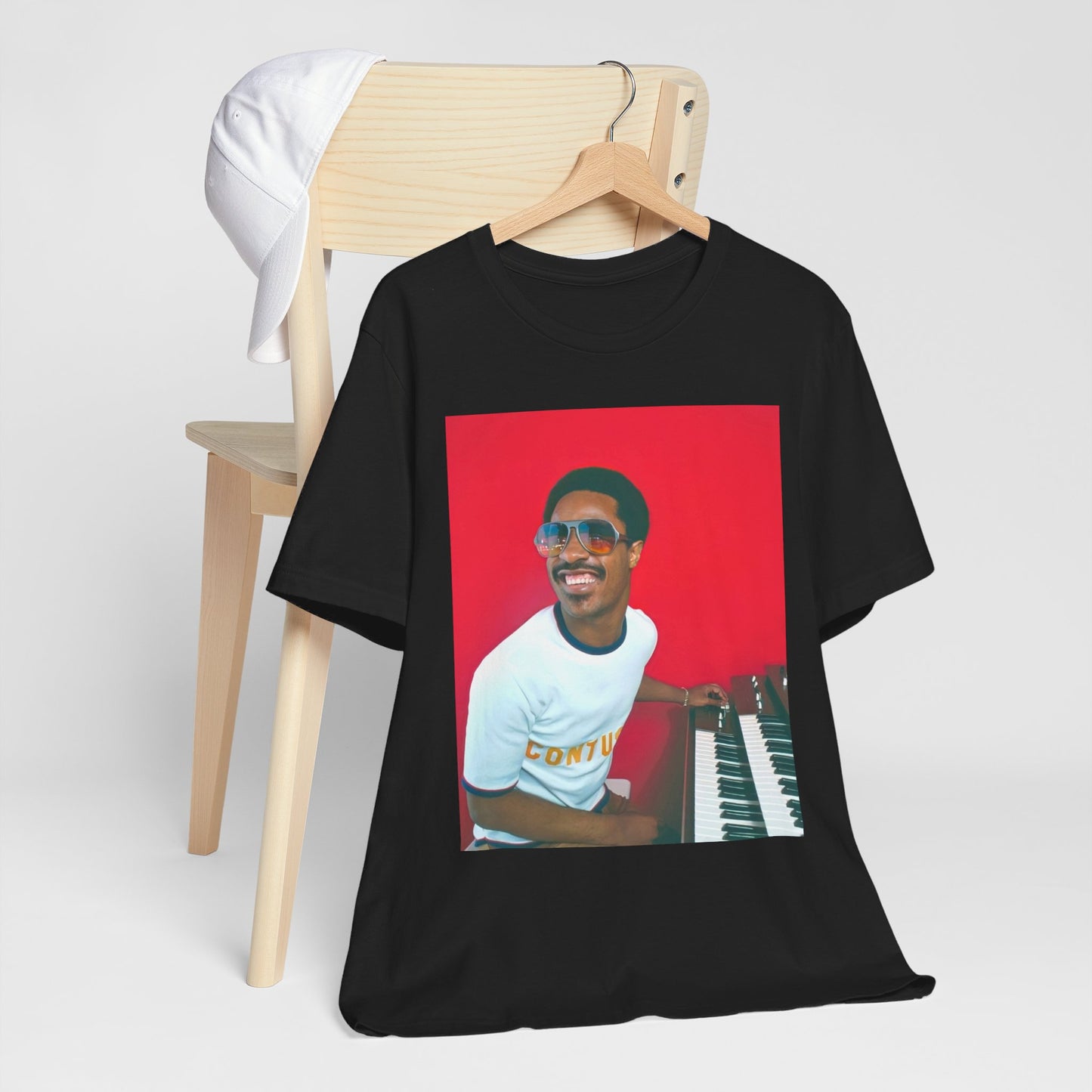 A black graphic t-shirt featuring a graphic of Stevie Wonder with a piano.