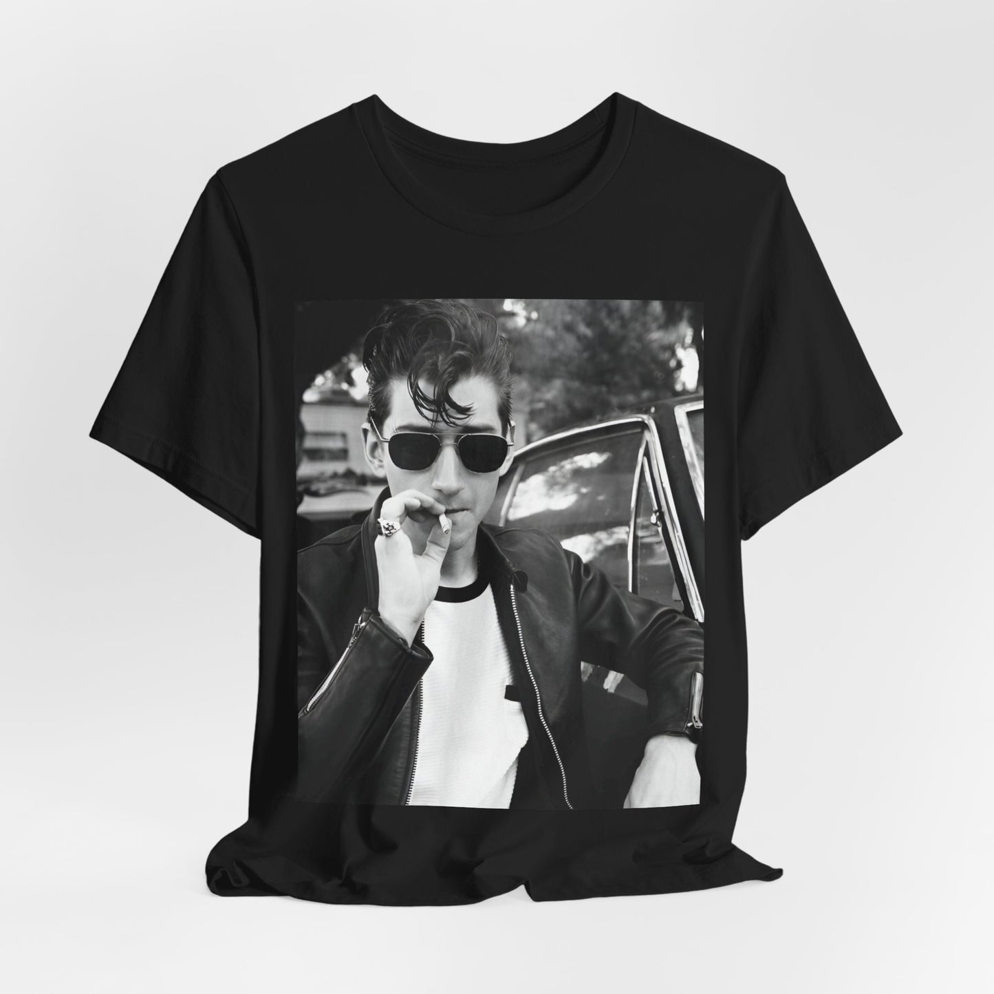 A black graphic t-shirt featuring a classic rock-style graphic of the Arctic Monkeys, possibly with band members in a stylized design.