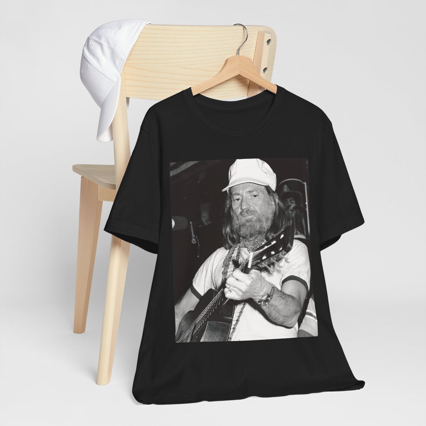 A black graphic t-shirt featuring a 70s cool free spirit graphic of Willie Nelson.