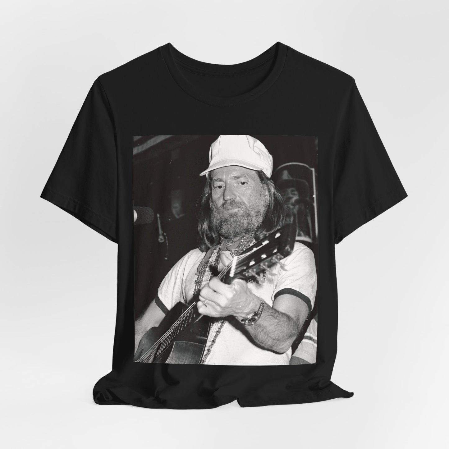 A black graphic t-shirt featuring a 70s cool free spirit graphic of Willie Nelson.