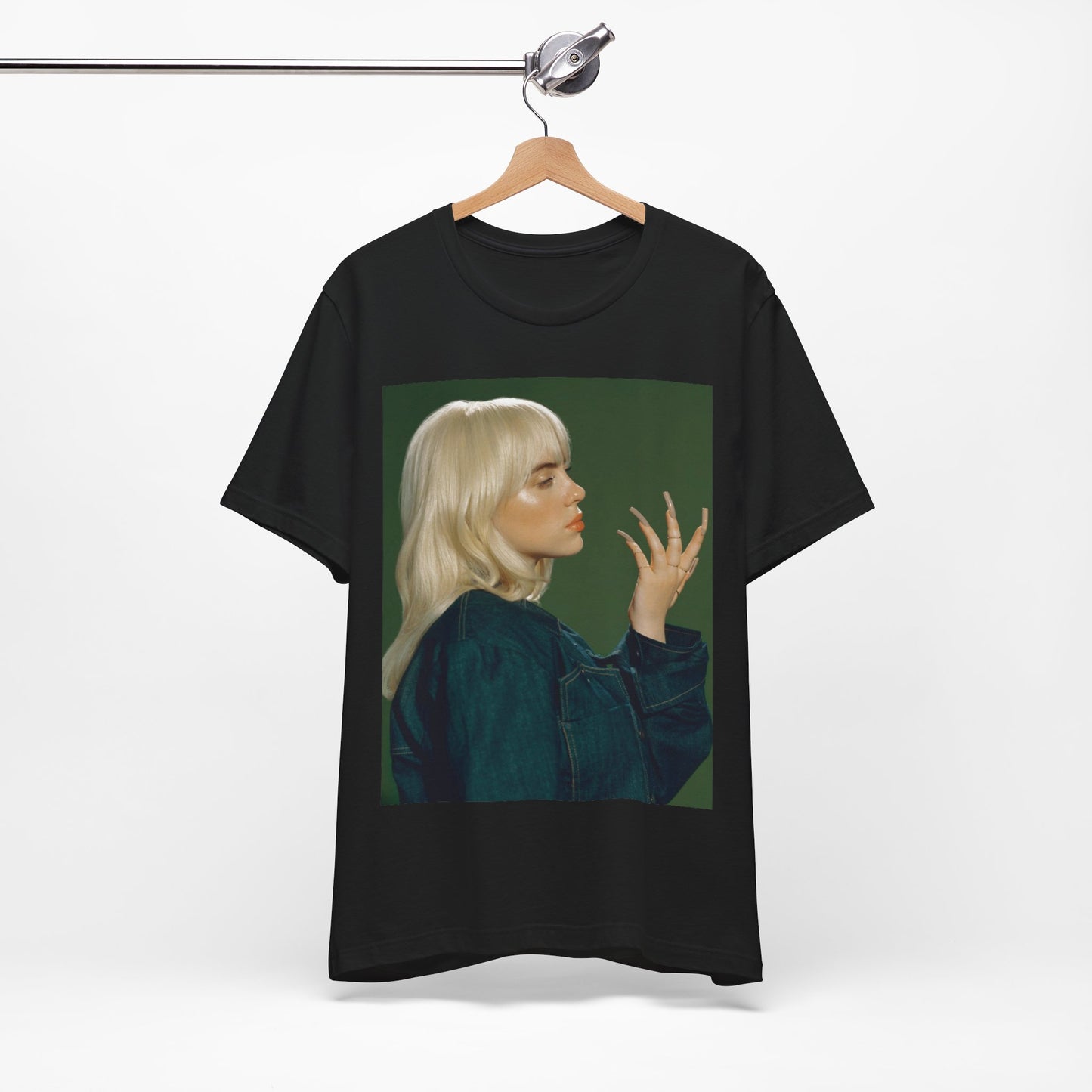 A vintage-style portrait of Billie Eilish with platinum blonde hair and long nails, wearing a denim jacket against a green background.