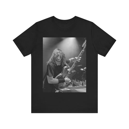 A black graphic t-shirt featuring a graphic of Dave Grohl from Foo Fighters playing guitar in concert.