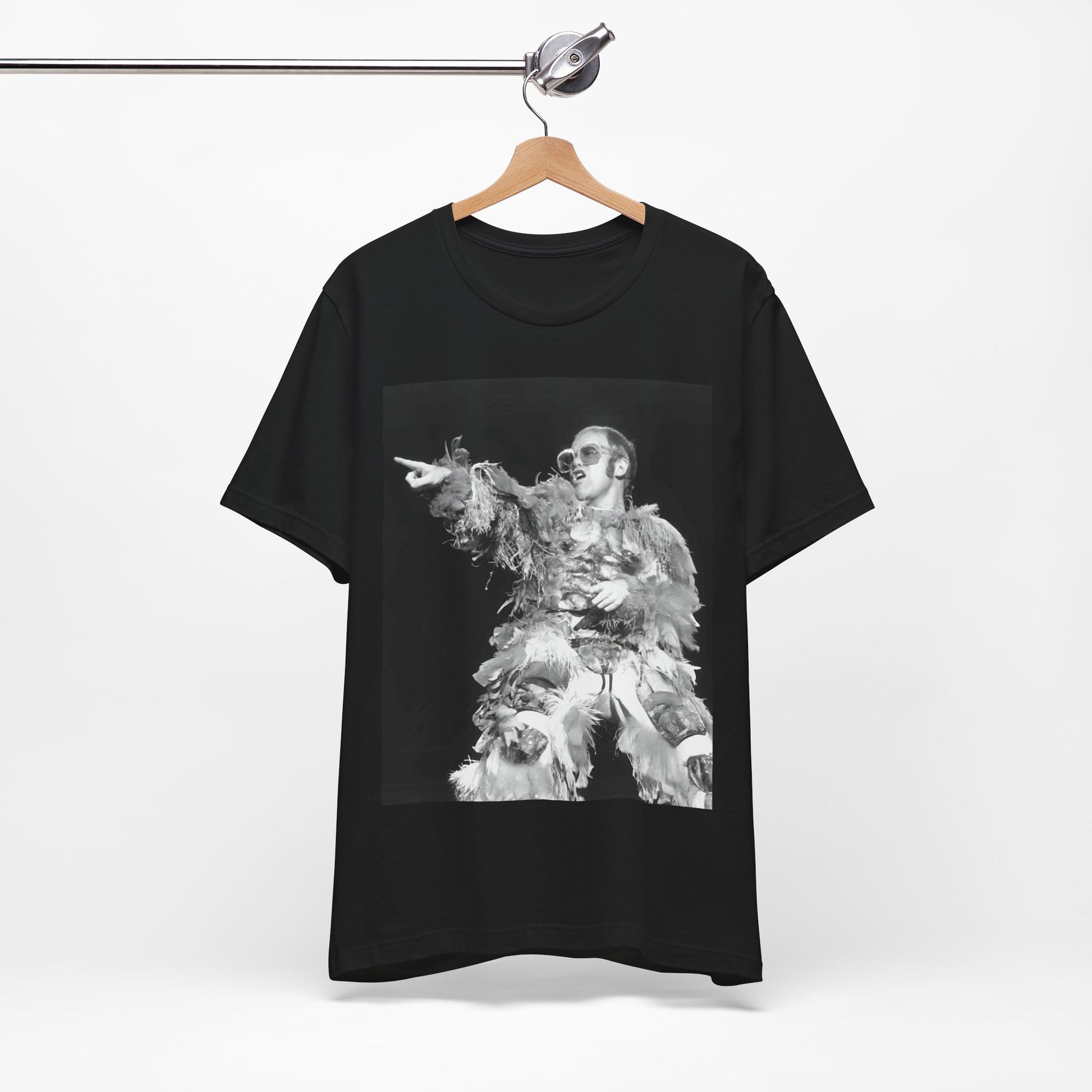 A black graphic t-shirt featuring a retro graphic of Elton John as a rock legend performing live.