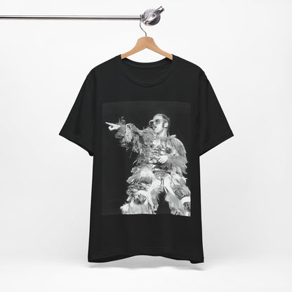 A black graphic t-shirt featuring a retro graphic of Elton John as a rock legend performing live.