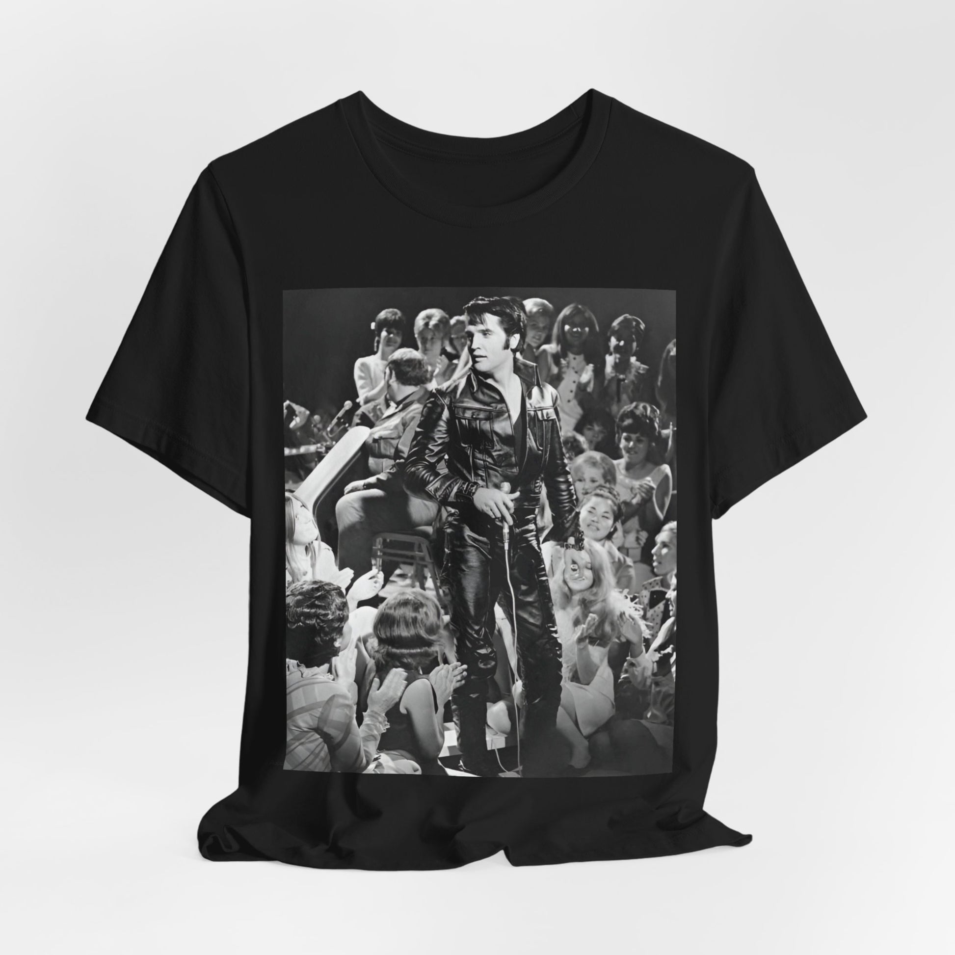 A black graphic t-shirt featuring a vintage black and white photo or graphic of Elvis Presley performing live on stage.