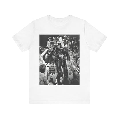 A black graphic t-shirt featuring a vintage black and white photo or graphic of Elvis Presley performing live on stage.