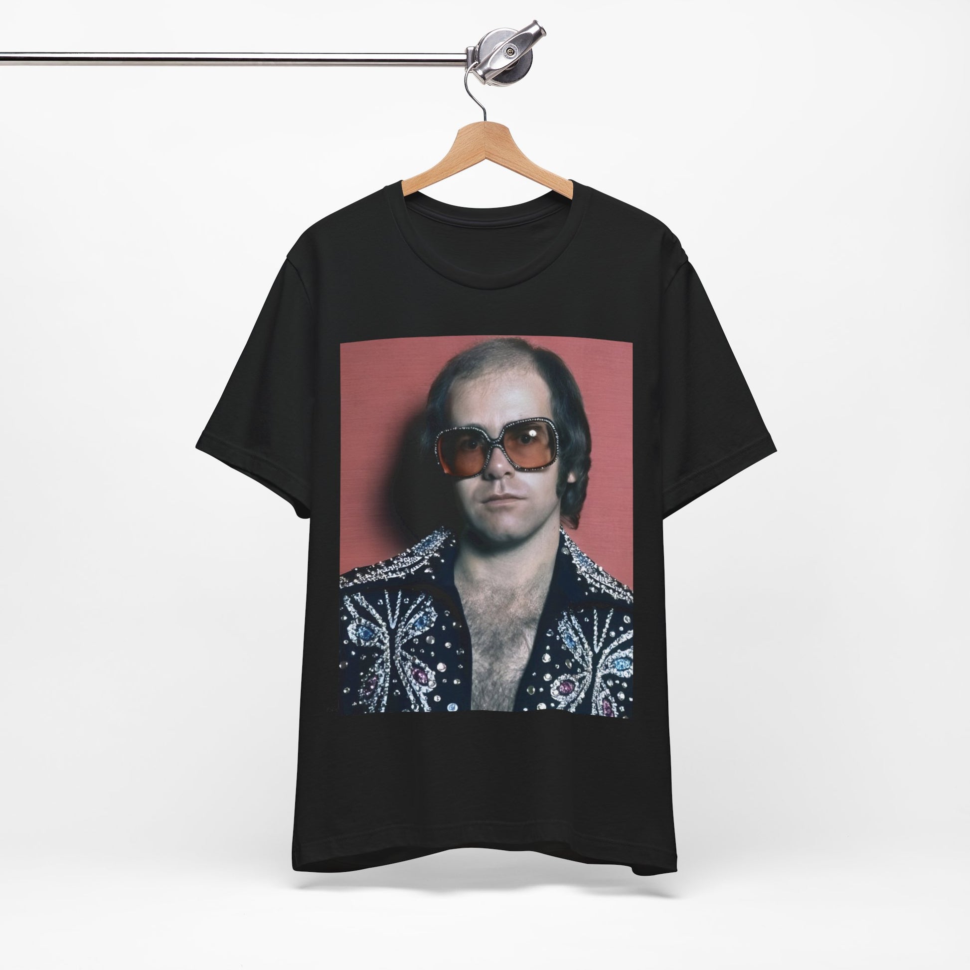A black graphic t-shirt featuring a vintage glam rock icon graphic of Elton John.