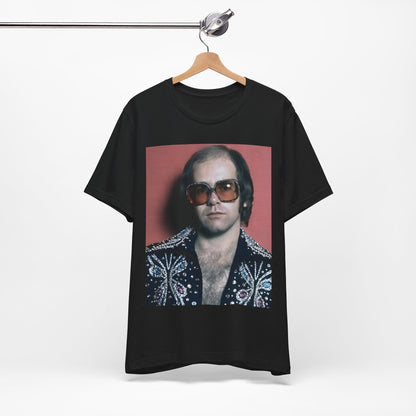 A black graphic t-shirt featuring a vintage glam rock icon graphic of Elton John.
