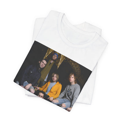 A high-energy, colorful photo of Maroon 5 performing live on stage at a concert, printed on a graphic t-shirt.