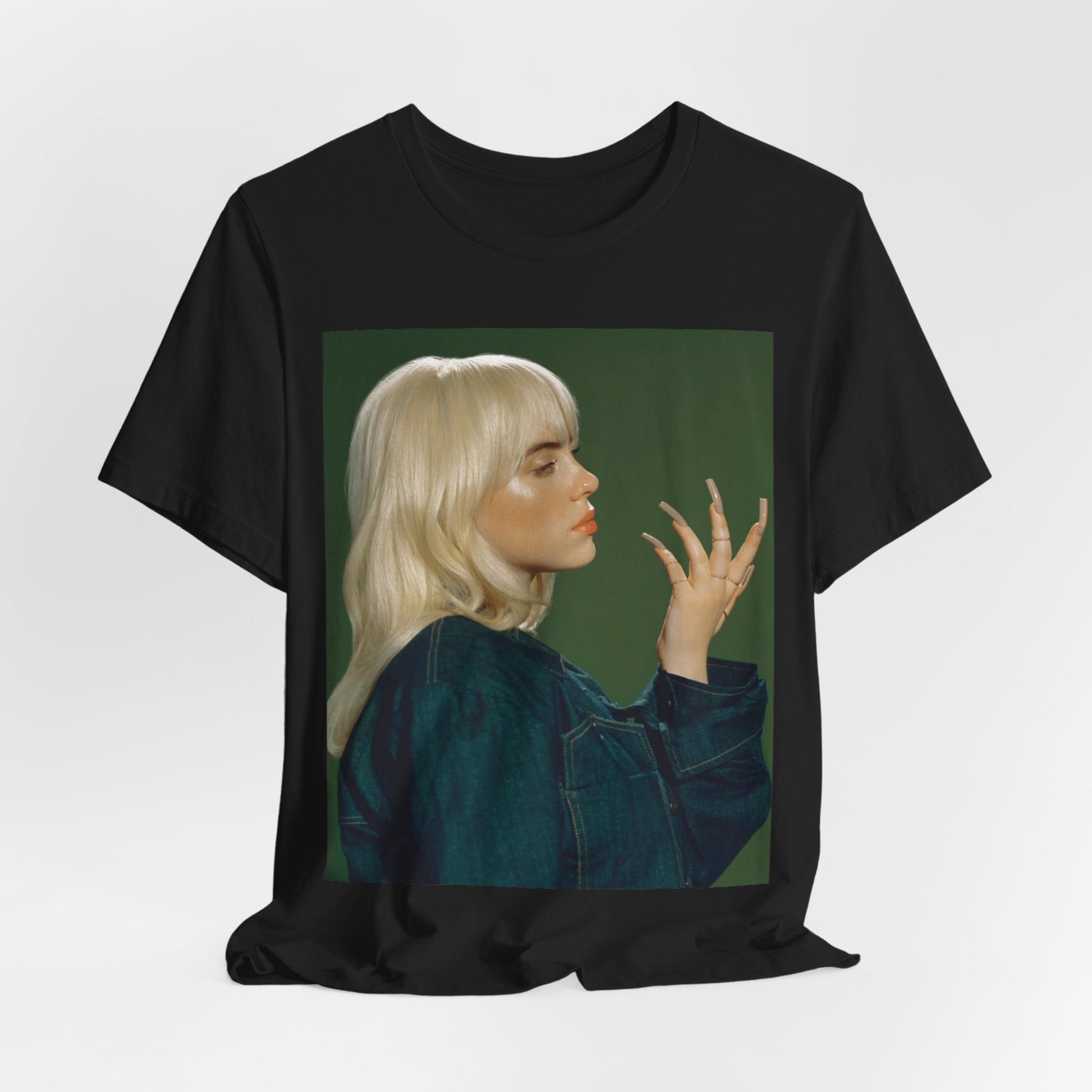 A vintage-style portrait of Billie Eilish with platinum blonde hair and long nails, wearing a denim jacket against a green background.