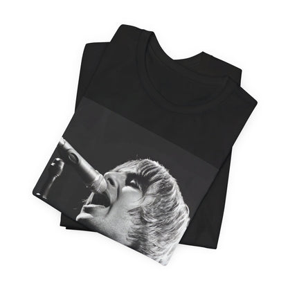 A black graphic t-shirt featuring a black and white graphic or photo of Liam Gallagher from Oasis performing live on stage.