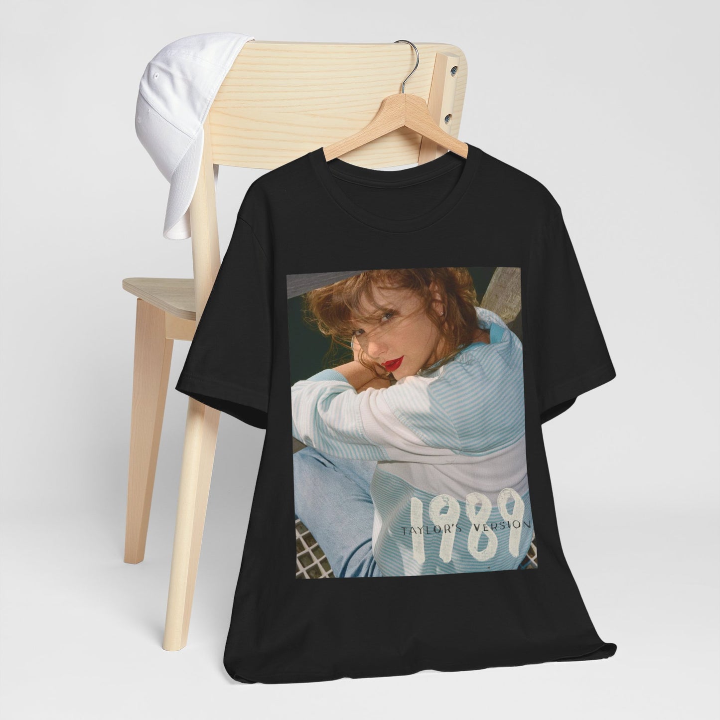 A black graphic t-shirt featuring a 1989 aesthetic graphic of Taylor Swift.