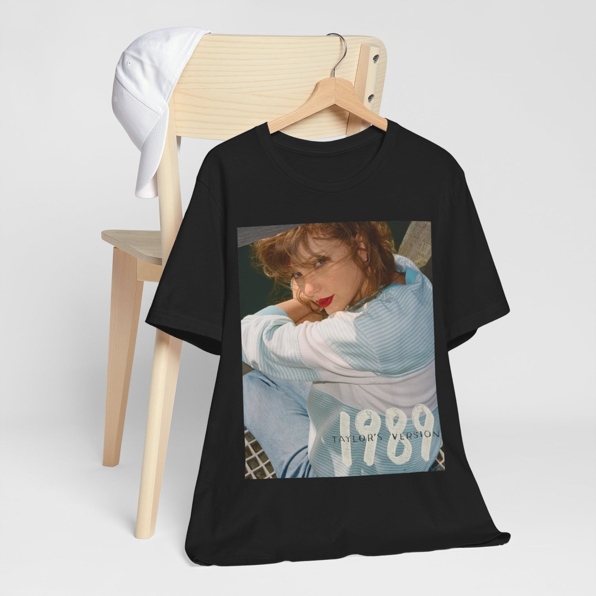 A black graphic t-shirt featuring a 1989 aesthetic graphic of Taylor Swift.