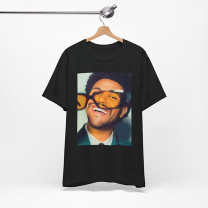 A black graphic t-shirt featuring a bold graphic of The Weeknd as a pop superstar.