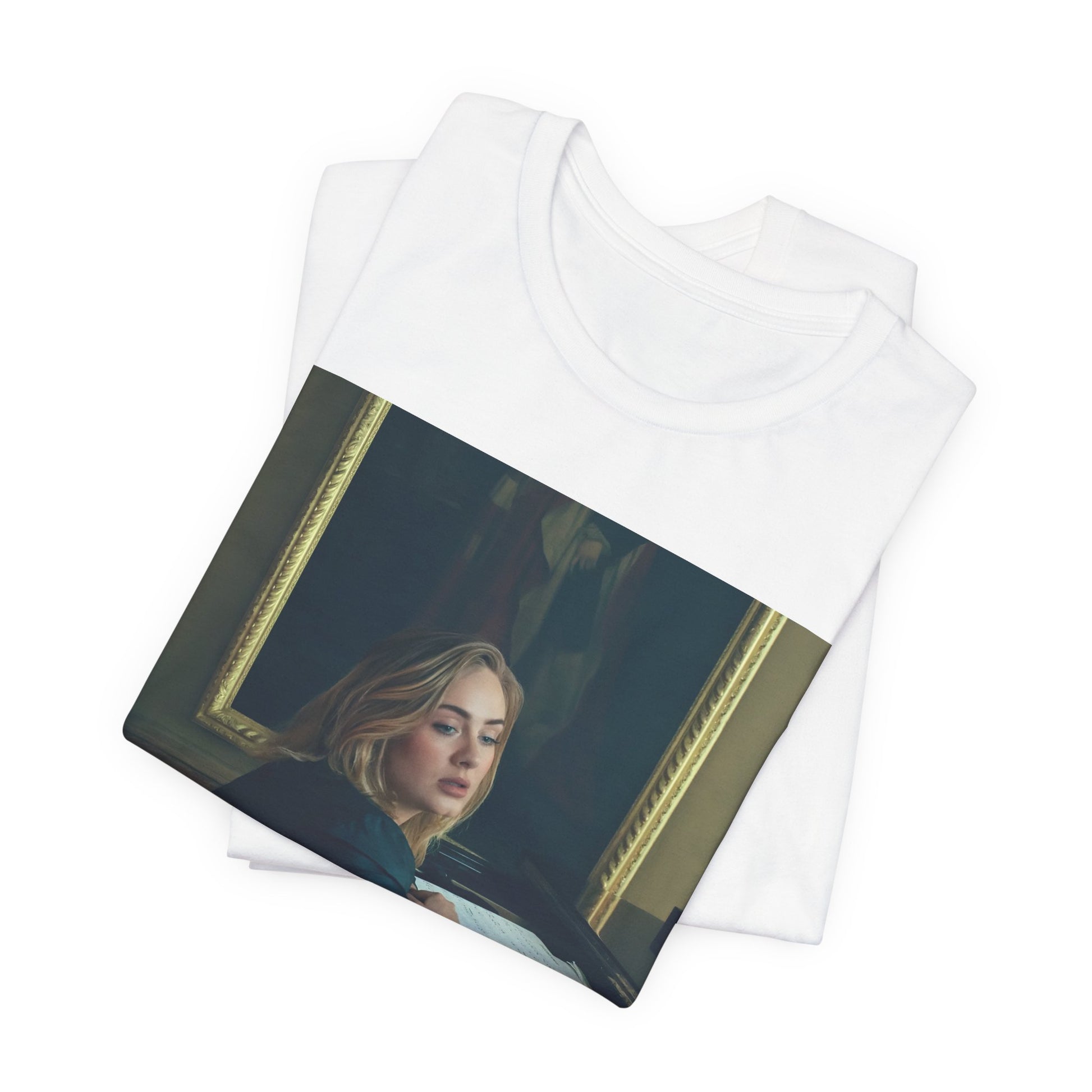 A black graphic t-shirt featuring a black and white photo of Adele sitting at a piano, with a focused and emotional expression as if performing.