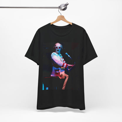 A black graphic t-shirt featuring a photo of Elton John performing live on stage at his piano.
