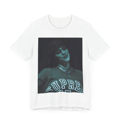 A powerful, close-up portrait of Billie Eilish with a direct and intense stare, printed on a graphic t-shirt.
