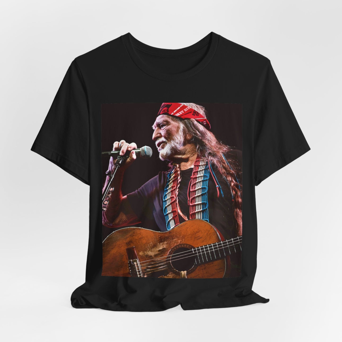 A black graphic t-shirt featuring a graphic of Willie Nelson with his iconic long hair and bandana.