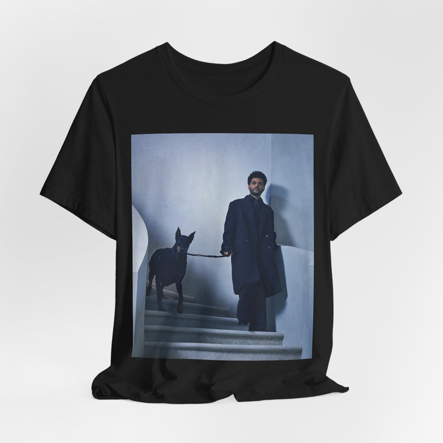 A black graphic t-shirt featuring a photo of The Weeknd with a doberman.