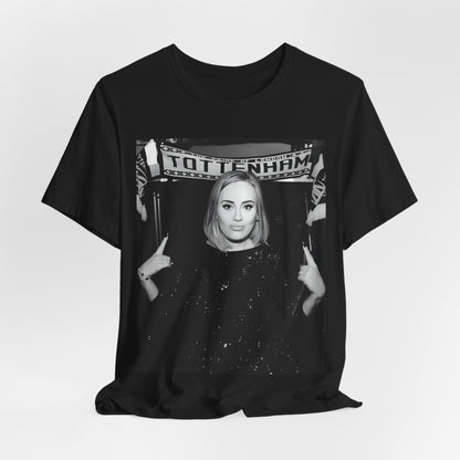 A black graphic t-shirt featuring a photo of Adele in a casual setting, surrounded by fans at a Tottenham event, showing her smiling or interacting.