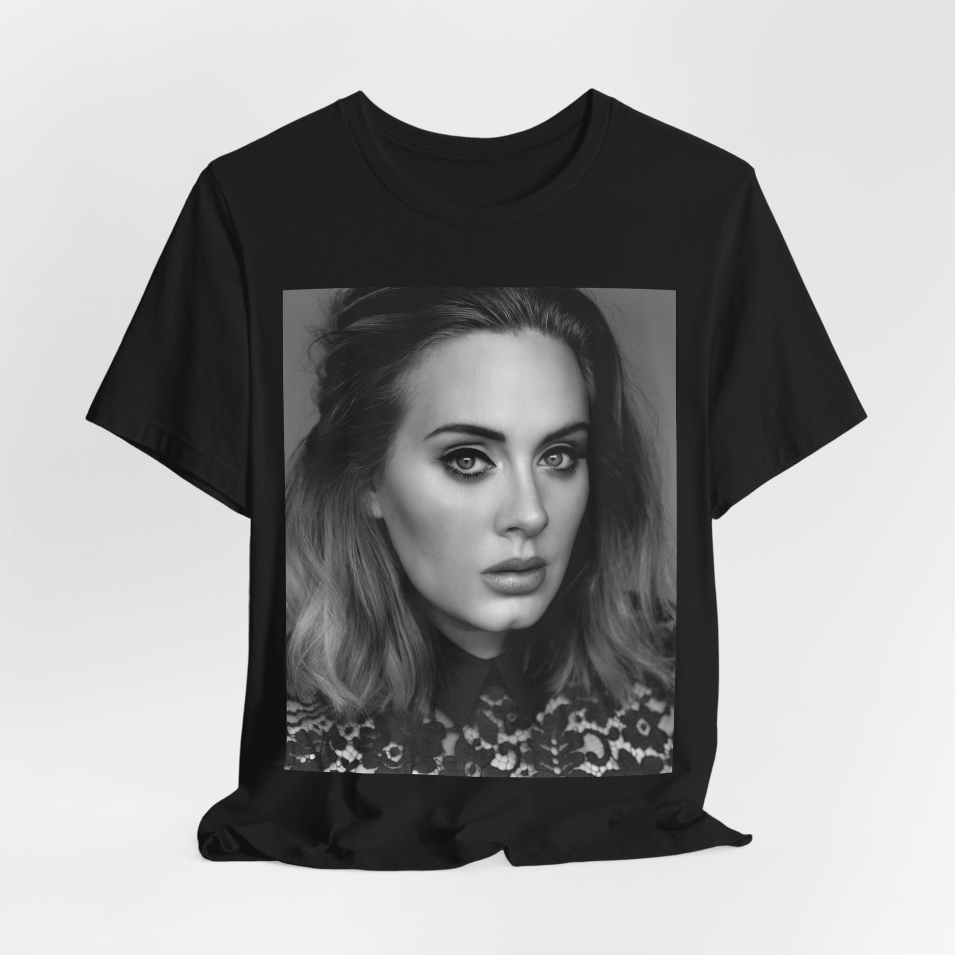A black graphic t-shirt featuring a classic black and white, monochrome portrait of Adele, showing her with a serene or thoughtful expression.
