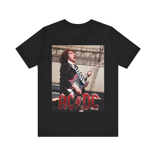 A graphic t-shirt featuring AC/DC's Angus Young in his schoolboy uniform, actively playing guitar on stage during a live concert.