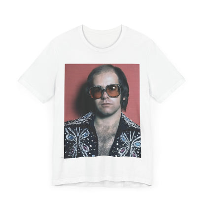 A black graphic t-shirt featuring a vintage glam rock icon graphic of Elton John.