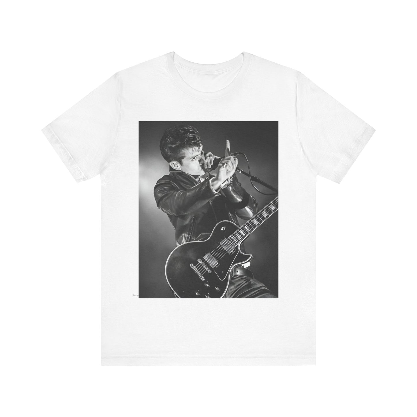 A black graphic t-shirt featuring a dynamic black and white graphic or photo of Arctic Monkeys performing live, emphasizing energy.