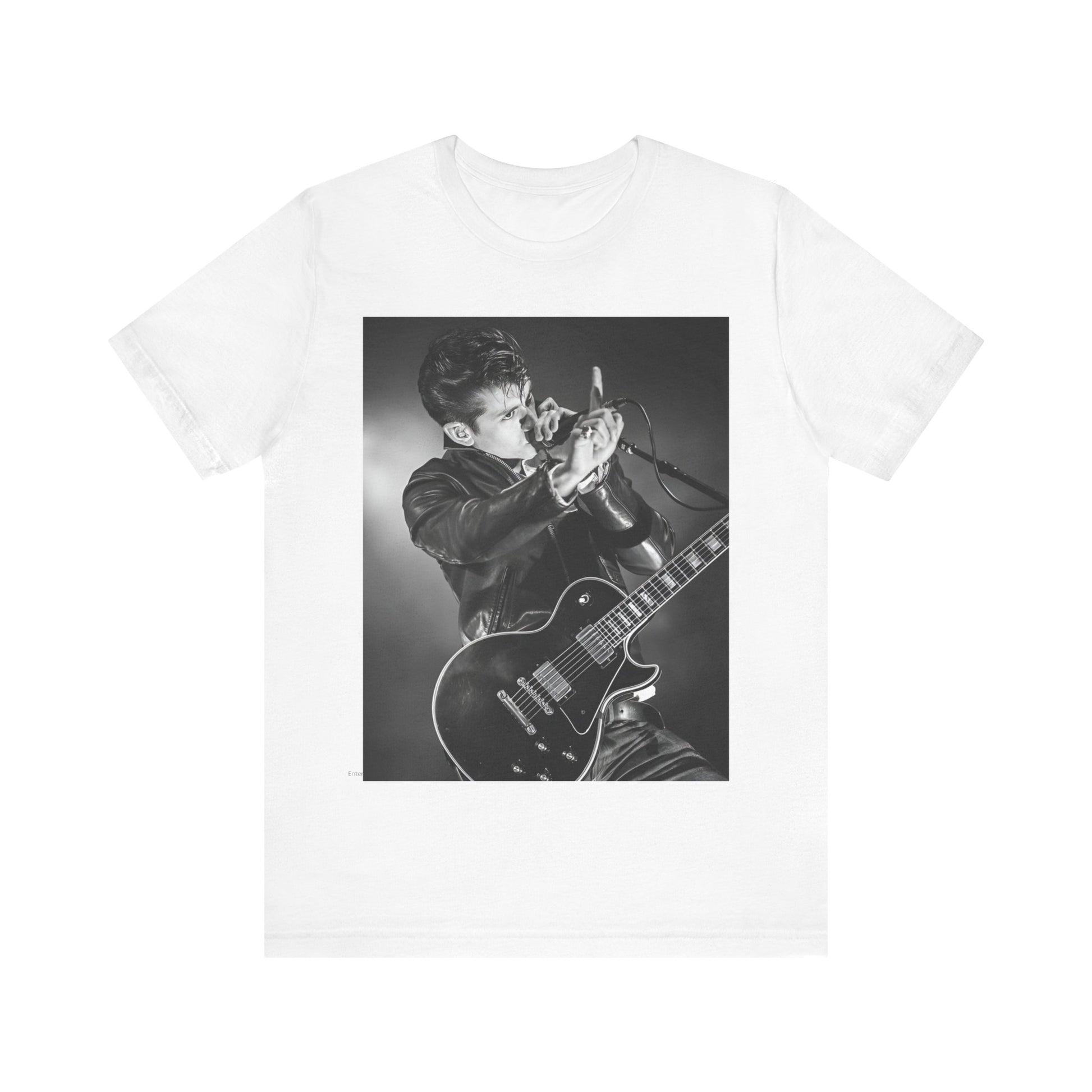 A black graphic t-shirt featuring a dynamic black and white graphic or photo of Arctic Monkeys performing live, emphasizing energy.