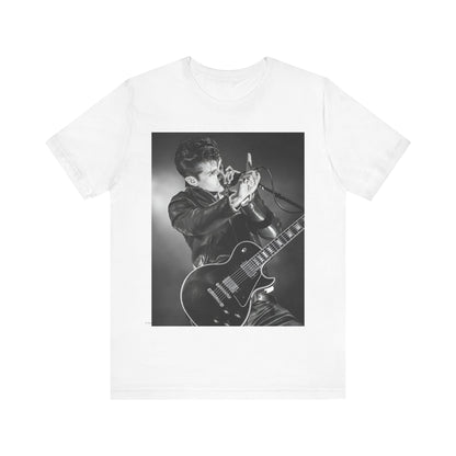 A black graphic t-shirt featuring a dynamic black and white graphic or photo of Arctic Monkeys performing live, emphasizing energy.