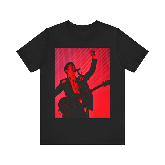 A black graphic t-shirt featuring a dynamic graphic or photo of Arctic Monkeys performing live in concert.