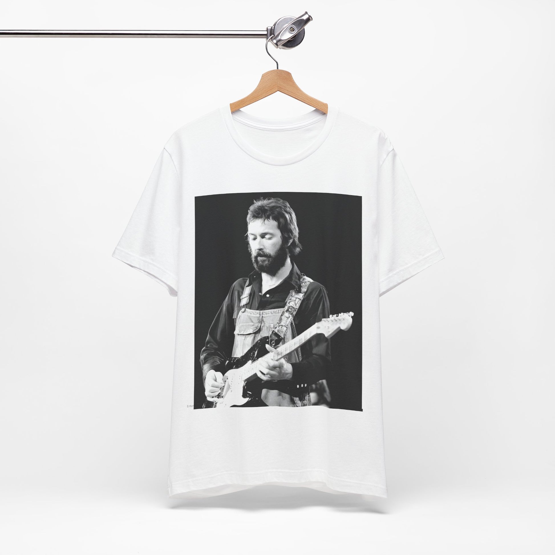 A black graphic t-shirt featuring a graphic or photo of Eric Clapton performing live on stage with his guitar.