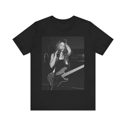 A black graphic t-shirt featuring a black and white graphic or photo of Shakira playing guitar live.