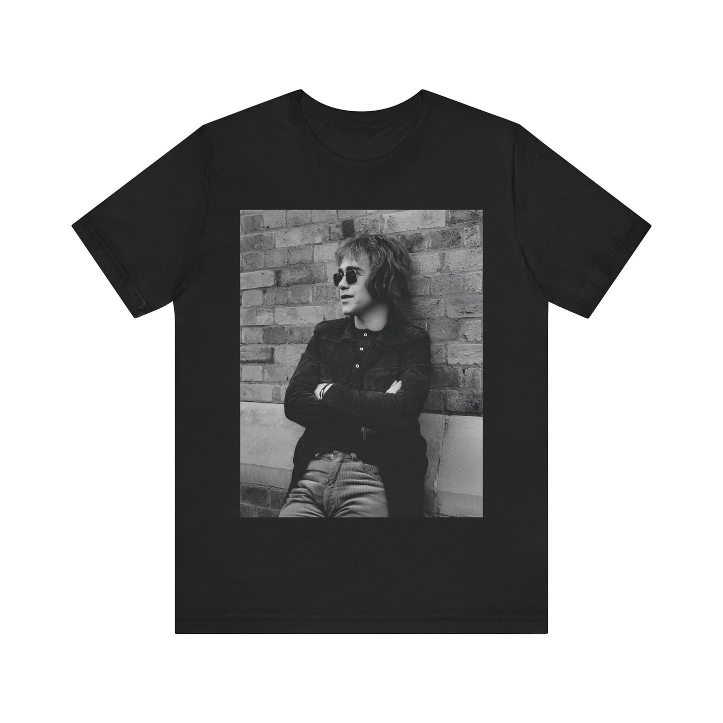 A black graphic t-shirt featuring a vintage graphic related to Elton John's 'Farewell Yellow Brick Road' tour.
