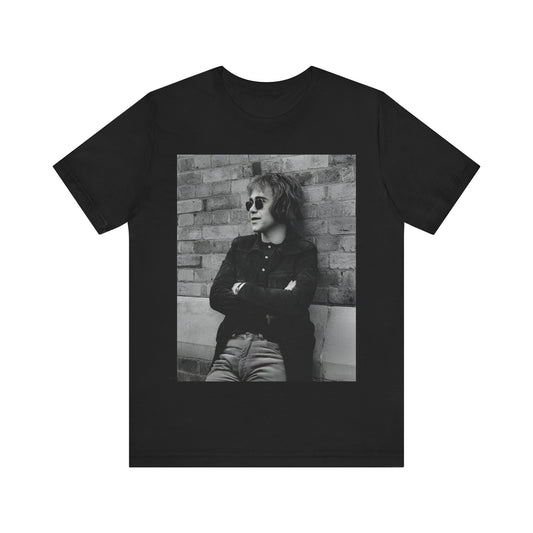 A black graphic t-shirt featuring a vintage graphic related to Elton John's 'Farewell Yellow Brick Road' tour.