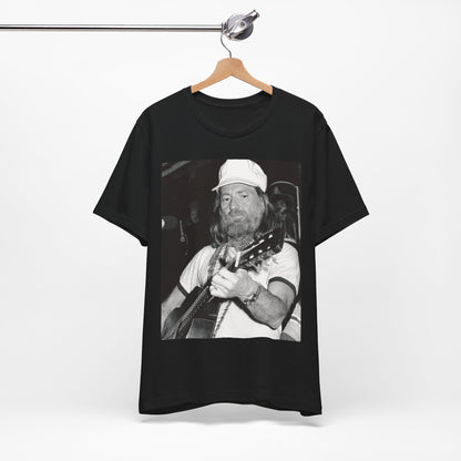 A black graphic t-shirt featuring a 70s cool free spirit graphic of Willie Nelson.