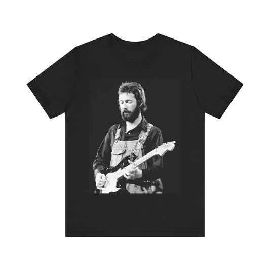 A black graphic t-shirt featuring a graphic or photo of Eric Clapton performing live on stage with his guitar.