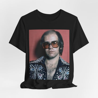 A black graphic t-shirt featuring a vintage glam rock icon graphic of Elton John.