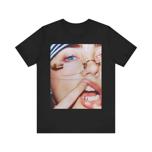 A direct, unfiltered, close-up portrait of Billie Eilish with dark hair looking straight at the camera, printed on a t-shirt.