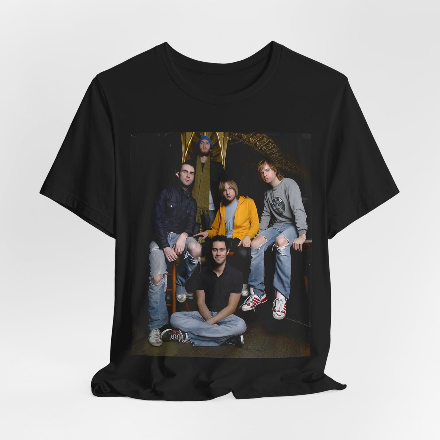 A high-energy, colorful photo of Maroon 5 performing live on stage at a concert, printed on a graphic t-shirt.