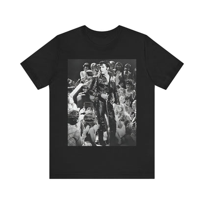 A black graphic t-shirt featuring a vintage black and white photo or graphic of Elvis Presley performing live on stage.