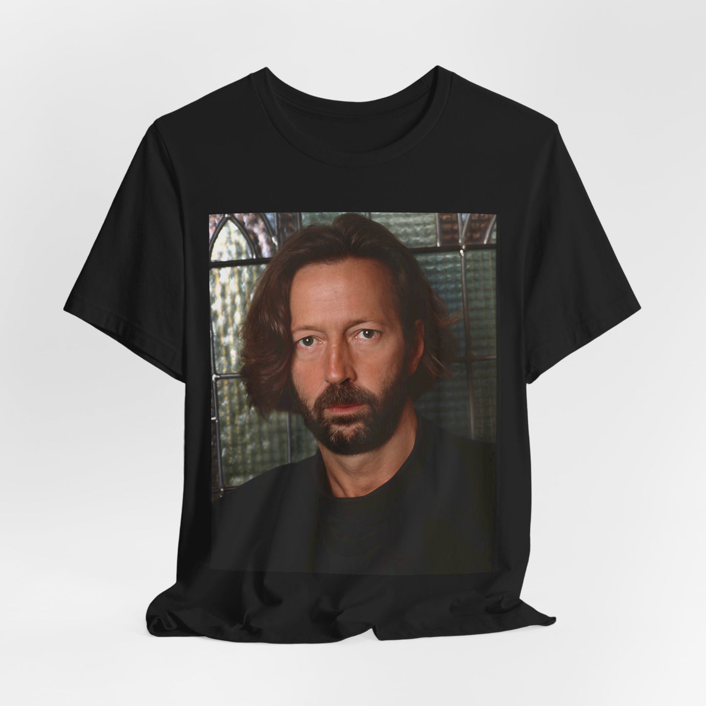 A black graphic t-shirt featuring a portrait graphic of Eric Clapton as a guitar god legend.