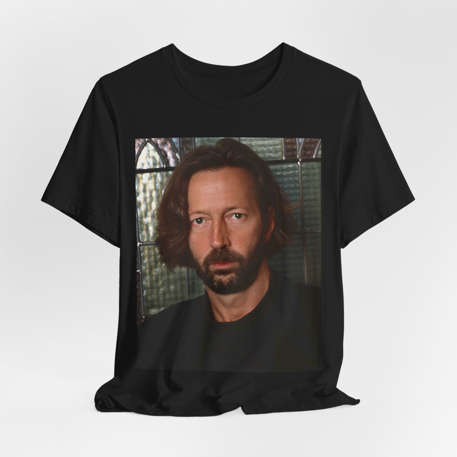 A black graphic t-shirt featuring a portrait graphic of Eric Clapton as a guitar god legend.
