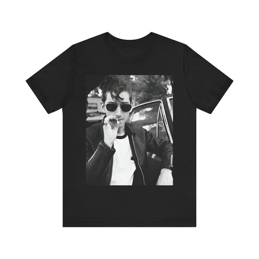 A black graphic t-shirt featuring a classic rock-style graphic of the Arctic Monkeys, possibly with band members in a stylized design.