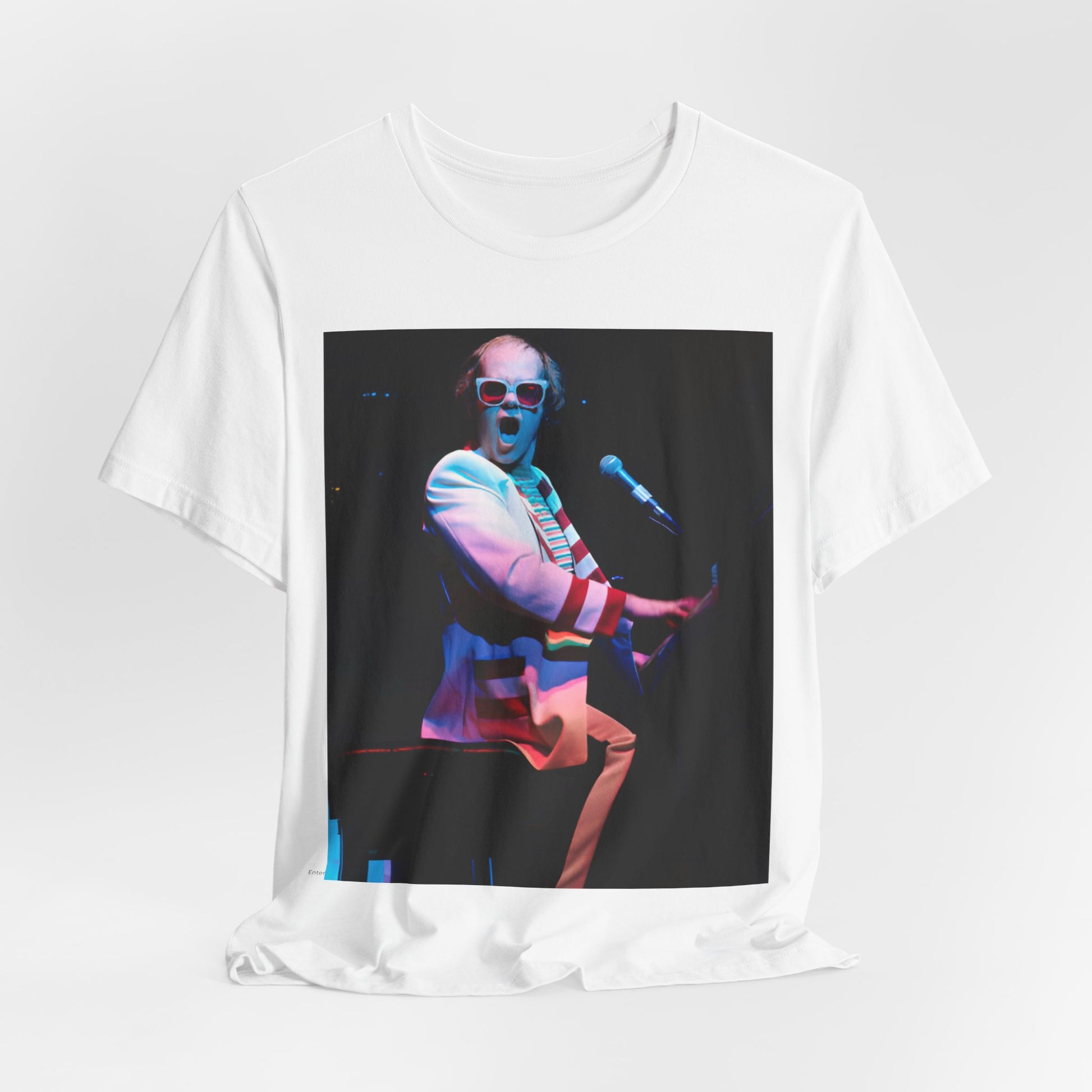 A black graphic t-shirt featuring a photo of Elton John performing live on stage at his piano.