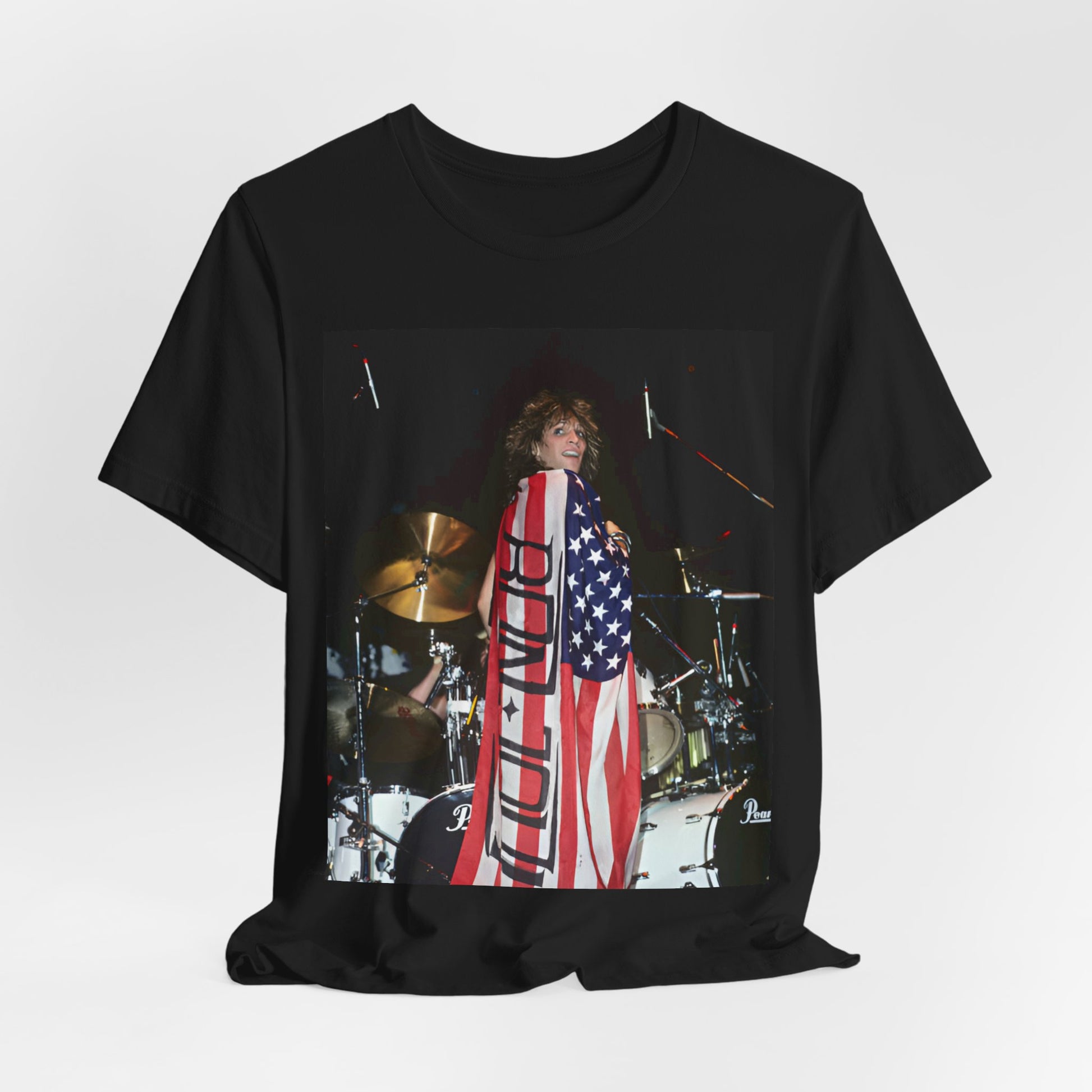 A black graphic t-shirt featuring a graphic of Bon Jovi performing on stage with an American flag as a backdrop.