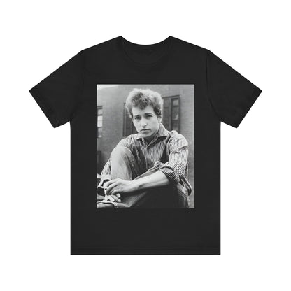 A black graphic t-shirt featuring a graphic of Bob Dylan from his 60s origins in folk music.